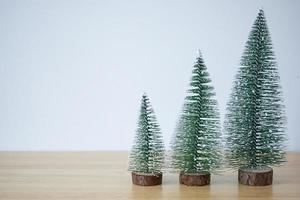 christmas tree on wood table with white wall background photo