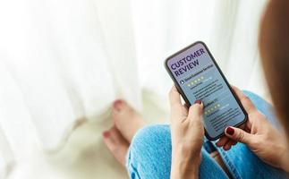 Customer Experience and Online Review Concept. Female sitting in house to Reading Customer Review in SmartPhone before Buying Products. Top view photo