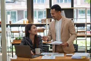 un equipo de hombres y mujeres de negocios diseñan un plan de marketing para ajustar las ventas para que sean más rentables que el año pasado. foto