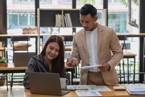 un equipo de hombres y mujeres de negocios diseñan un plan de marketing para ajustar las ventas para que sean más rentables que el año pasado. foto