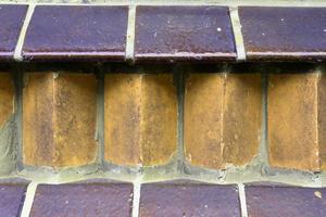 Detailed view at a colorful old and weathered brick wall texture as a panoramic background. photo