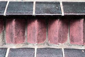 Detailed view at a colorful old and weathered brick wall texture as a panoramic background. photo