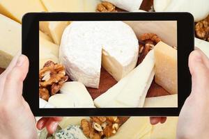 tourist taking photo of assortment of cheeses