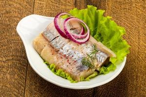 Herring fillet in a bowl on wooden background photo