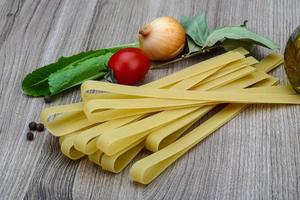 fettuccine sobre fondo de madera foto