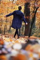 vista trasera de una mujer disfrutando de un paseo otoñal en el bosque foto