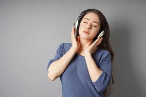 mujer joven escuchando música con auriculares foto