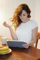 young woman using tablet computer at home photo