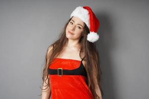 mujer joven vestida con traje de navidad y sombrero de santa foto