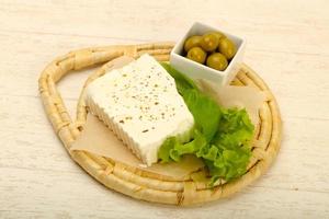 Feta cheese on wooden board and wooden background photo