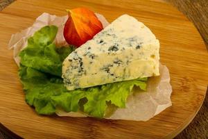 Blue cheese on wooden board and wooden background photo