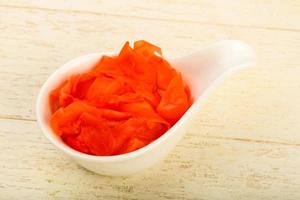 Picked ginger in a bowl on wooden background photo