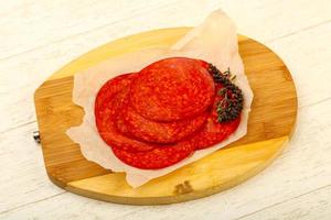 Sliced chorizo on wooden board and wooden background photo