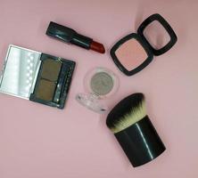 Cosmetic brush, blush, red lipstick and eye shadow photo