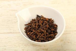 Clove in a bowl on wooden background photo