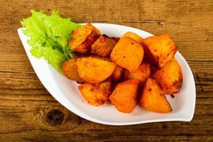 Baked potato in a bowl on wooden background photo