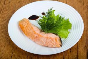 Steamed salmon on the plate and wooden background photo