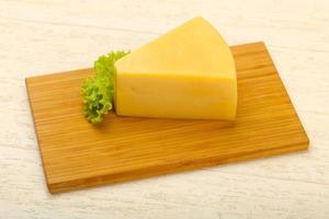 Parmesan cheese on wooden board and wooden background photo