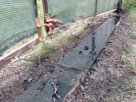 Spraying liquid bituminous mastic on the concrete foundation for insulation photo
