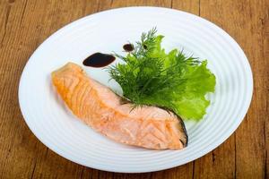 Steamed salmon on the plate and wooden background photo