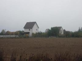 Panorama of a plowed field in the village at sunset photo