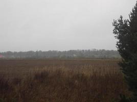 Panorama of a plowed field in the village at sunset photo