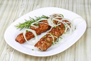 Beef kebab on the plate and wooden background photo