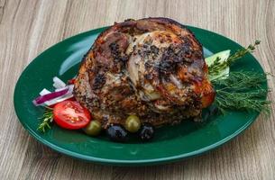 Pork knee on the plate and wooden background photo