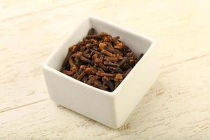 Clove in a bowl on wooden background photo