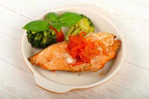 Baked Salmon in a bowl on wooden background photo