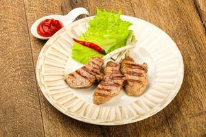 Grilled lamb on the plate and wooden background photo