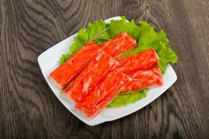 Crab sticks on the plate and wooden background photo