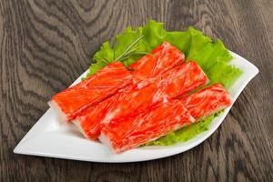 Crab sticks on the plate and wooden background photo