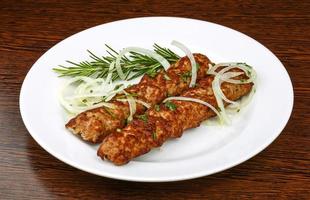 Beef kebab on the plate and wooden background photo