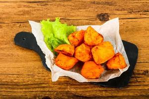 Baked potato on wooden board and wooden background photo