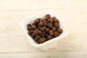 Pepper corn in a bowl on wooden background photo