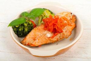 Baked Salmon in a bowl on wooden background photo