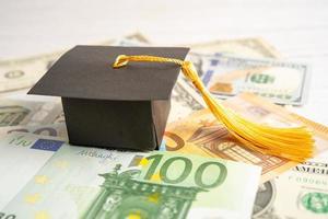 Sombrero de brecha de graduación en dólares estadounidenses y billetes en euros, concepto de enseñanza de aprendizaje de tarifa de estudio de educación. foto