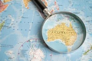 Bangkok, Thailand - May 01, 2022 Austialia, Magnifying glass close up with colorful world map photo