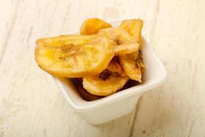 Dry banana in a bowl on wooden background photo