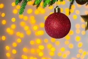 árbol de navidad decorado con bola roja sobre fondo de ramas de pino foto