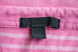 etiqueta de ropa negra en blanco para el cuidado de la ropa en la textura de la tela foto