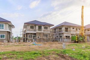 New house building at residential estate construction site with clouds and blue sky photo