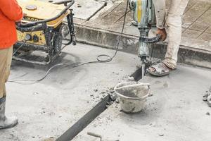trabajador de la construcción con martillo perforador de superficie de hormigón foto