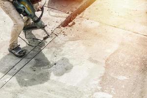 Construction worker using jackhammer drilling concrete surface photo