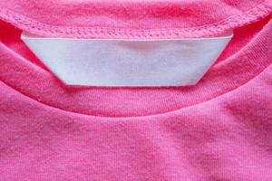 etiqueta de ropa en blanco para el cuidado de la ropa en la camisa rosa foto