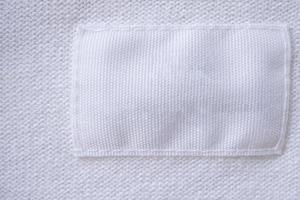 Blank white clothes label on new shirt background photo