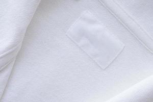 Blank white clothes label on new shirt background photo