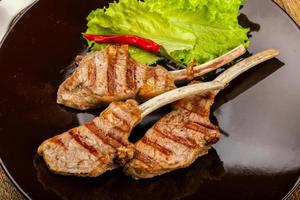 Grilled lamb on the plate and wooden background photo