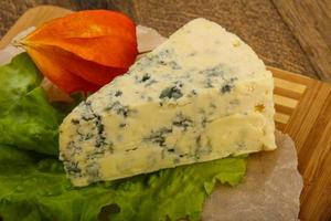 Blue cheese on wooden board and wooden background photo